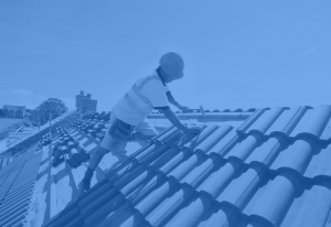 A roofer sets red clay roofing tiles